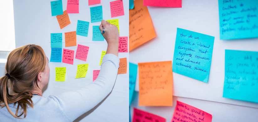 Left: Woman writes on multi-colored post-it notes on white wall; Right: Closeup of post-its, center note reads "How do we create a vibrant ecosystem that supports, resources, and advances actionable science."